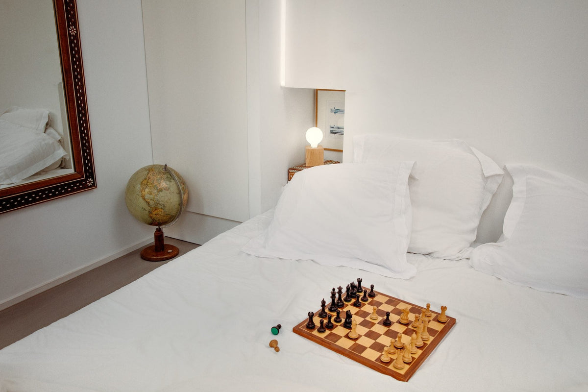 Chambre lumineuse avec un échiquier sur le lit