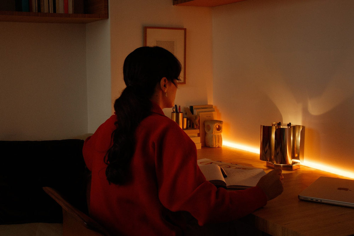 Femme à son bureau éclairé le soir